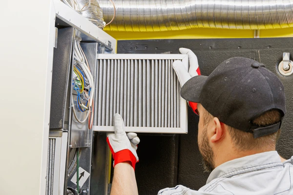 HVAC technician replacing furnace filter in Warren MI